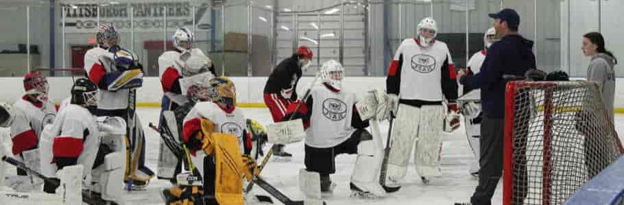 Group of goalies listening to instructions with JS in front of net
