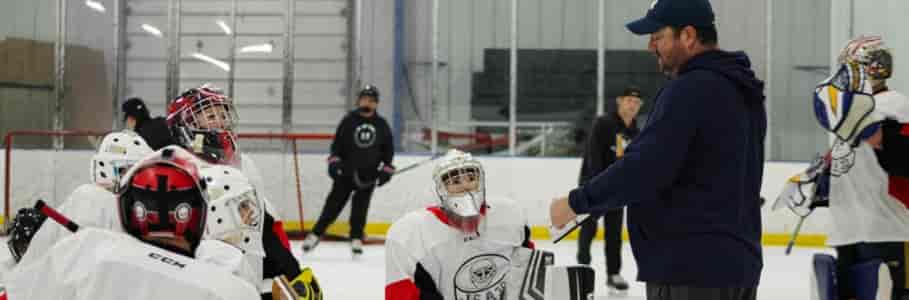 A couple of goalies watching JS describe a plan on a board